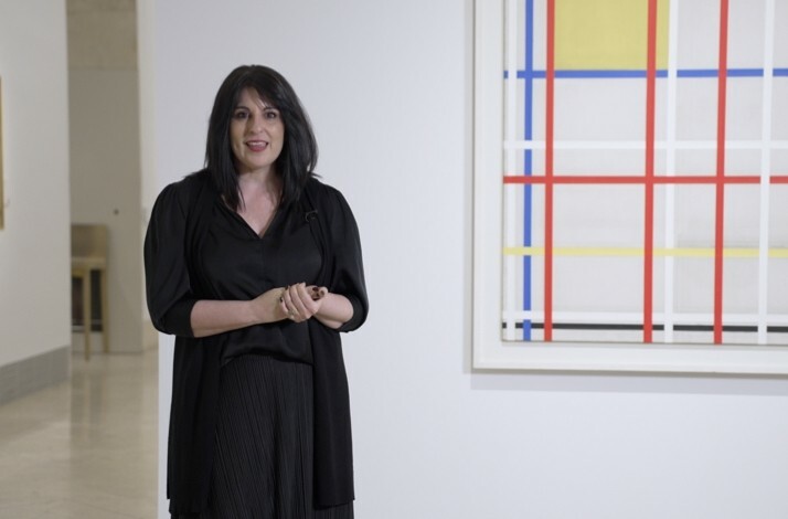 The woman is standing in front of the painting of Piet Mondrian at the Thyssen-Bornemisza Museum.