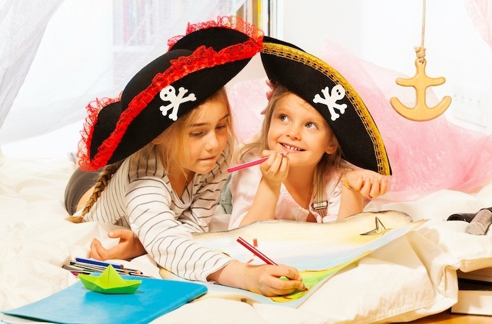 Two girls dressed like pirates are busy with drawing at a pirate training session at the Miami Children's Museum.