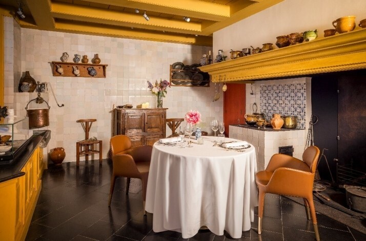 A cozy kitchen featuring a wooden table surrounded by chairs at Rembrandt's former house.