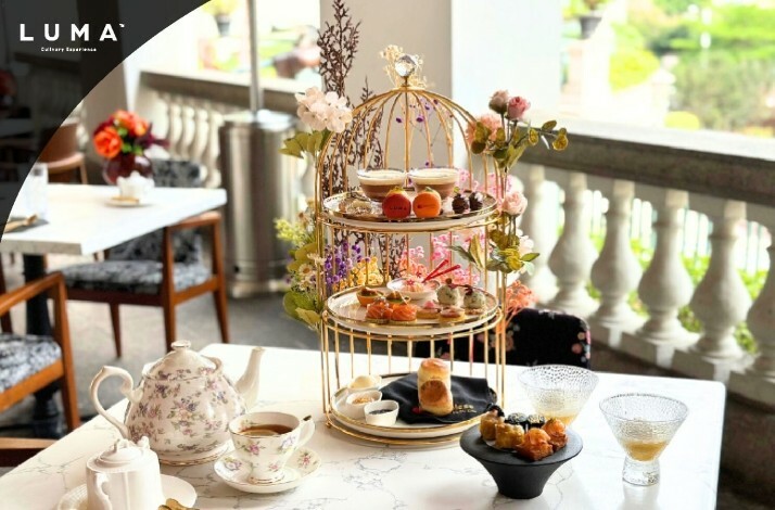 Dessert stand of tea set on a table with garden view at LUMA.