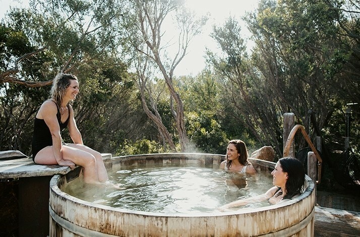 Three people enjoying the private bath in Peninsula Hot Springs resort