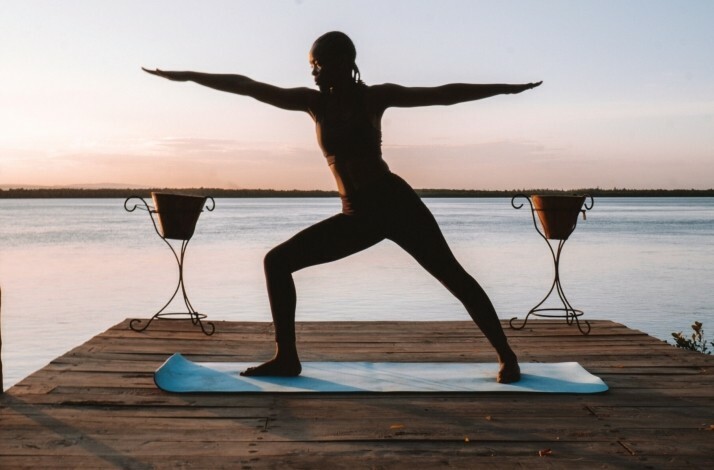 The lady is practicing yoga by the Indian Ocean