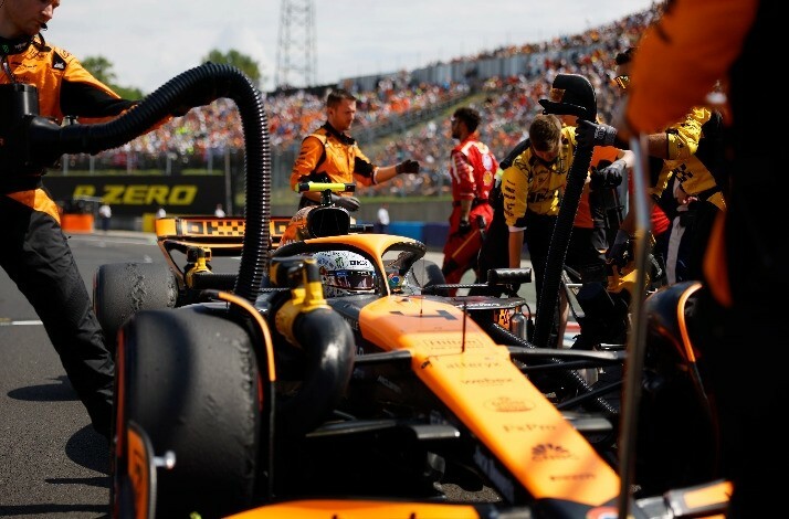 Members of McLaren Formula 1 Team on racetrack.